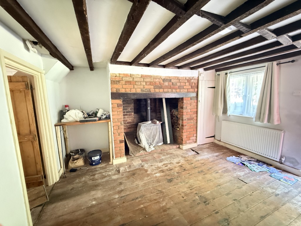 Lot: 134 - HOUSE FOR IMPROVEMENT WITH EXTENSIVE GARDEN - Living room with fireplace